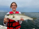 Happy client with Lake Texoma striper and lake backdrop, Stripers Inc.